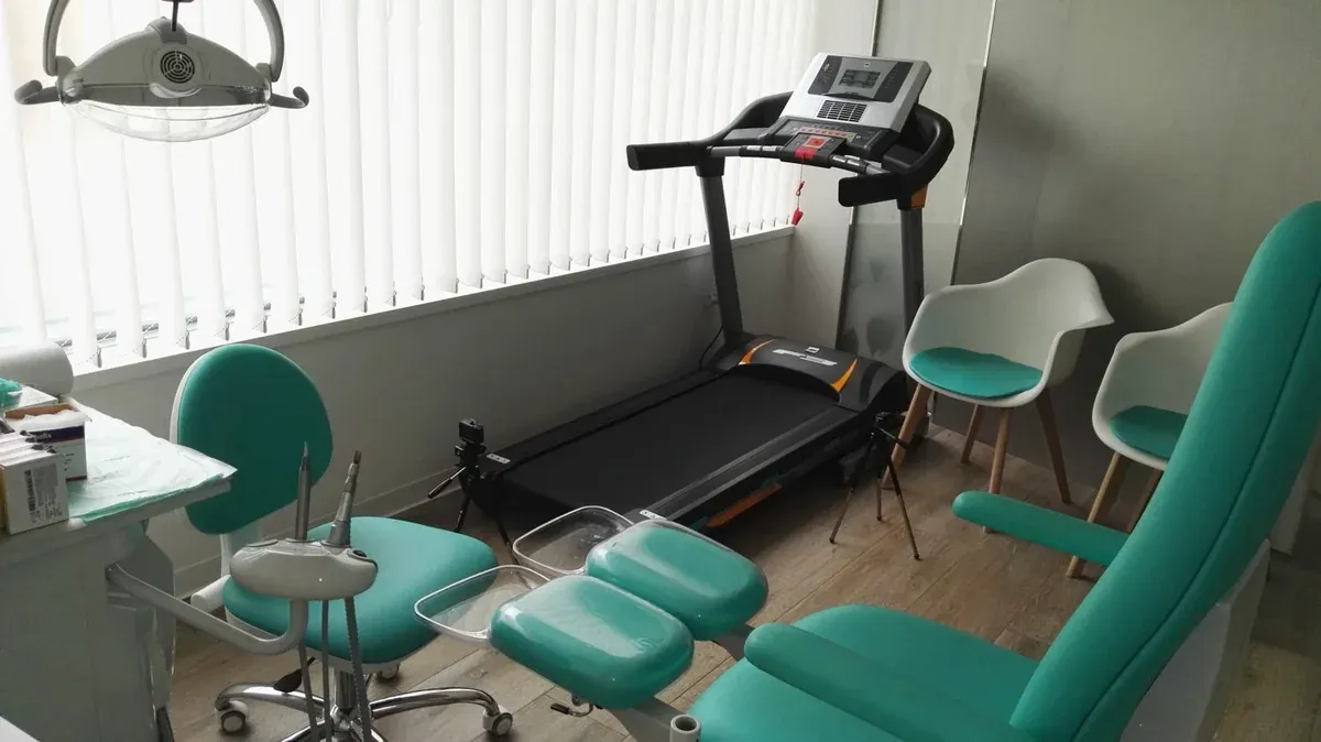 Sala de la Clínica Podológica Nuria Infantes con el sillón podológico turquesa y el instrumental de exploración.