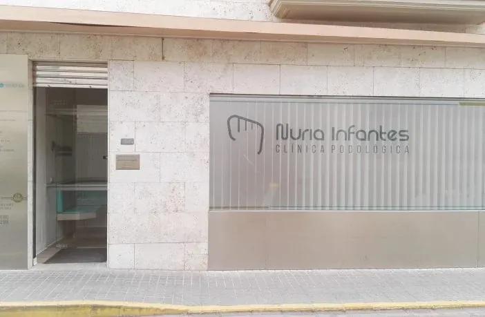 Fachada de la Clínica Podológica Nuria Infantes en Daimiel, con el rótulo corporativo en el escaparate.